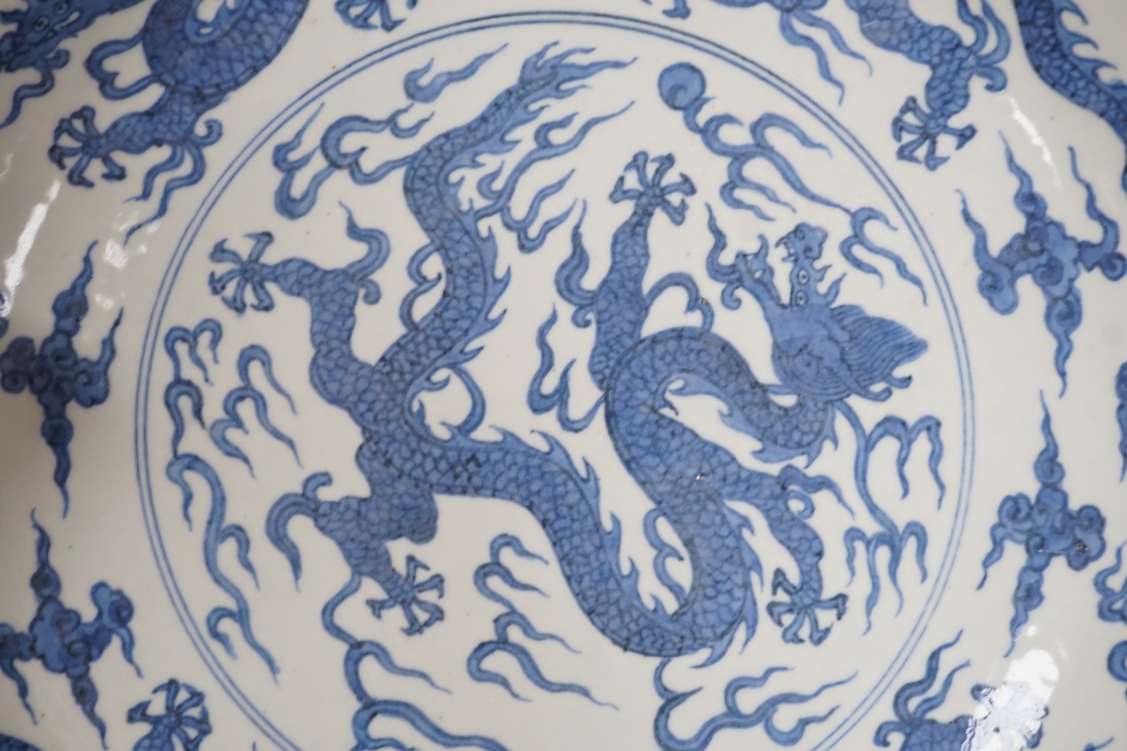 A Chinese blue and white ‘dragon’ dish, marked to base, 28cm diameter, together with a Samson blue and white ground serving dish with gilt decoration